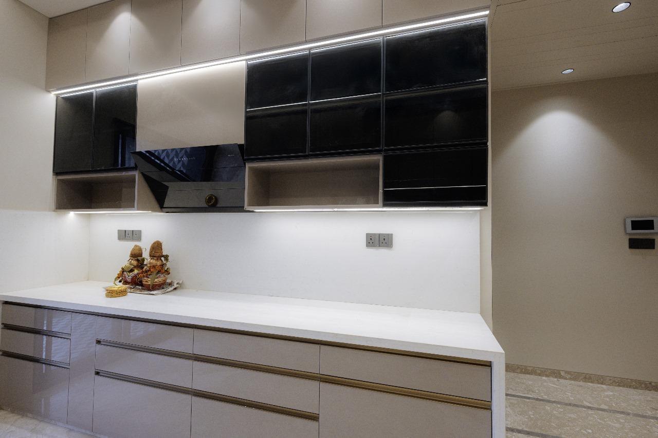 Taupe modular kitchen counter with black glass panel cabinet detail